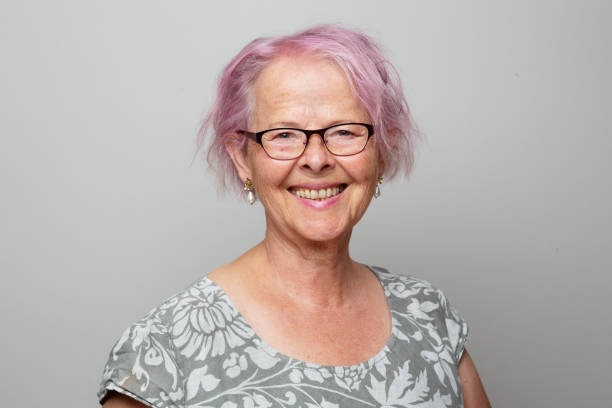 Portait of a senior woman with pink hair, smiling stock photo