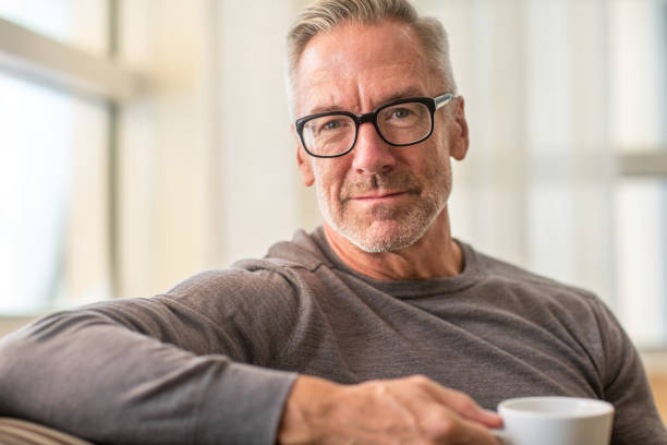 Portarit of a handsome older man drinking coffee Portrait of a handsome older man drinking coffee at home mature men stock pictures, royalty-free photos & images