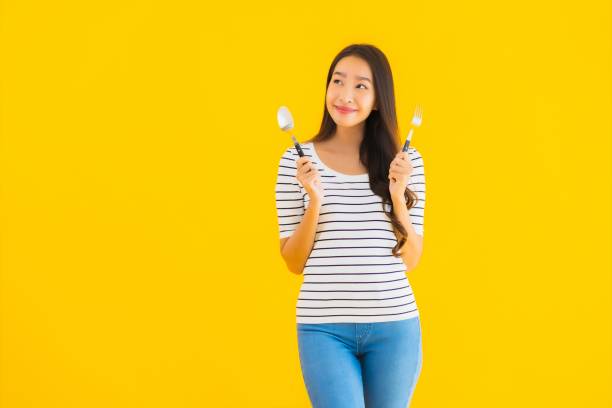 Portrait beautiful young asian woman show spoon and fork ready to eat stock photo