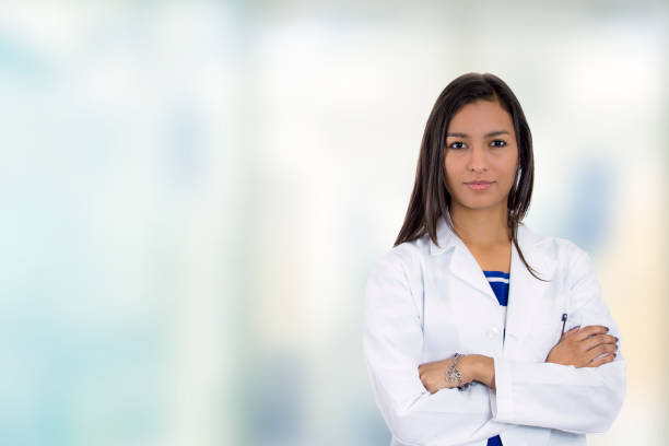 portrait confident young female doctor medical professional standing in corridor - aluno dentista imagens e fotografias de stock