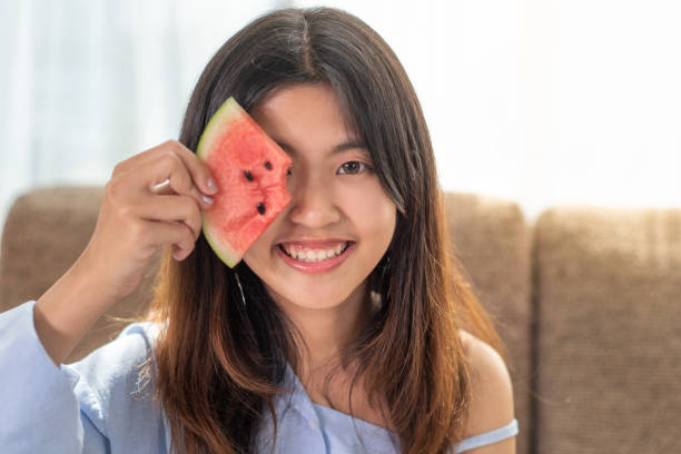 Portrait happy young Asian woman is holding slice of watermelon Portrait happy young Asian woman is holding slice of watermelon, funny and happiness concept watermelon stock pictures, royalty-free photos & images