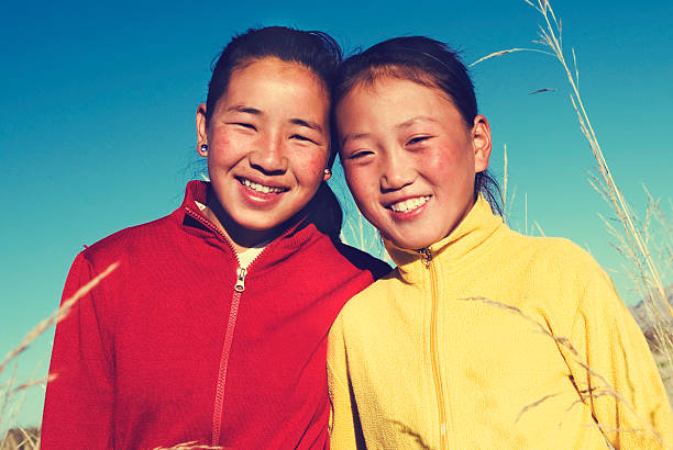 porträt mangolian zwei schwestern schönen lächelnden konzept - rawpixel stock-fotos und bilder