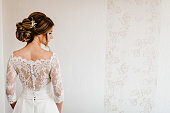 Portrait of a beautiful stylish bride with an elegant hairstyle view from the back. Wedding, people, fashion and beauty concept - bride in wedding dress. Back view.