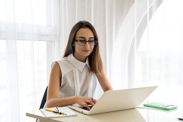 Portrait of a businesswoman in glasses use laptop  in office stock photo