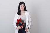 花輪を持つクリスマスの手に陽気なアジアの女性の肖像画