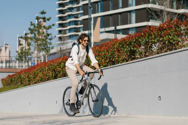 Portrait of a cheerful, young environmentalist riding his bicycle to work stock photo
