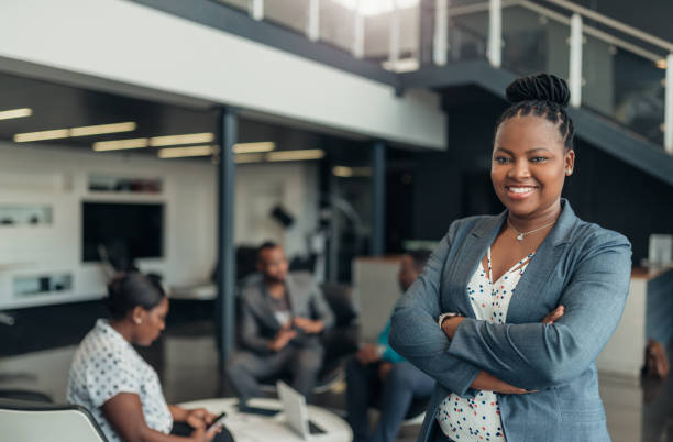 Portrait of a confident black businesswoman with all african american team in the background Confident black business people. africa stock pictures, royalty-free photos & images