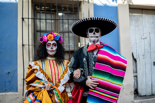 Portrait of a couple celebrating the day of the dead with makeup and traditional clothing