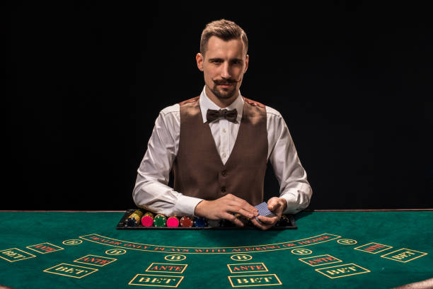 一個小矮人的肖像是拿著撲克牌,賭籌碼在桌子上。黑色背景 - texas shooting 個照片及圖片檔