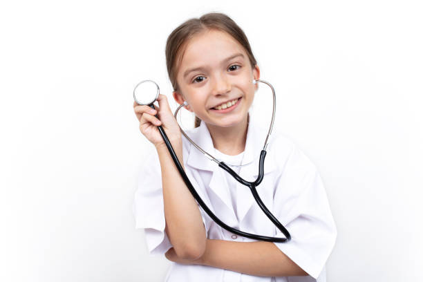 Portrait of a cute little girl dressed as a doctor with a stethoscope. stock photo