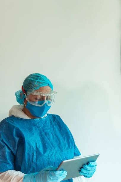 retrato de una doctora que lleva una máscara médica con una tableta digital - nurse talking to camera fotografías e imágenes de stock
