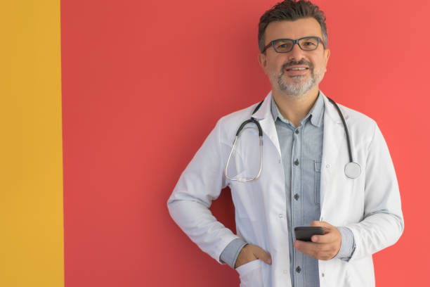 portrait of a handsome doctor using smartphone. - doctor wall imagens e fotografias de stock
