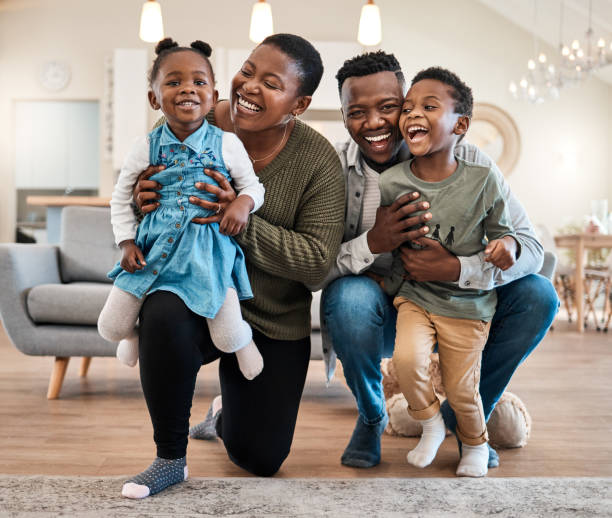 Portrait of a happy young family spending quality time at home stock photo