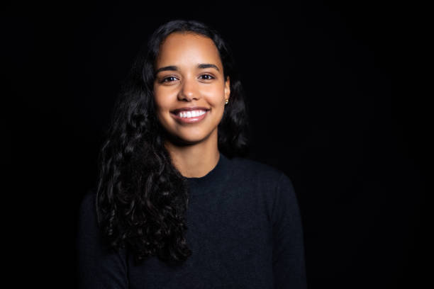 Portrait of a happy young latin american woman on black background stock photo