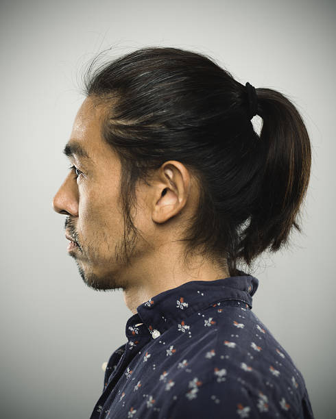 Portrait of a japanese man looking at camera Studio portrait of a japanese man with relaxed expression. The man has around 40 years and has long hair and casual clothes. Vertical color image from a medium format digital camera. Sharp focus on eyes. mutton chops stock pictures, royalty-free photos & images