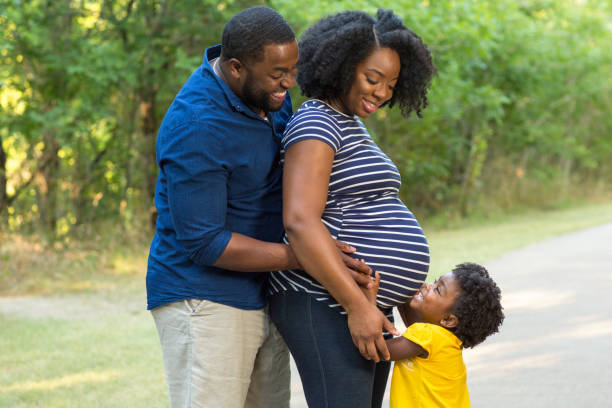 portret van een zwangere afro-amerikaanse familie. - pregnant couple outside stockfoto's en -beelden