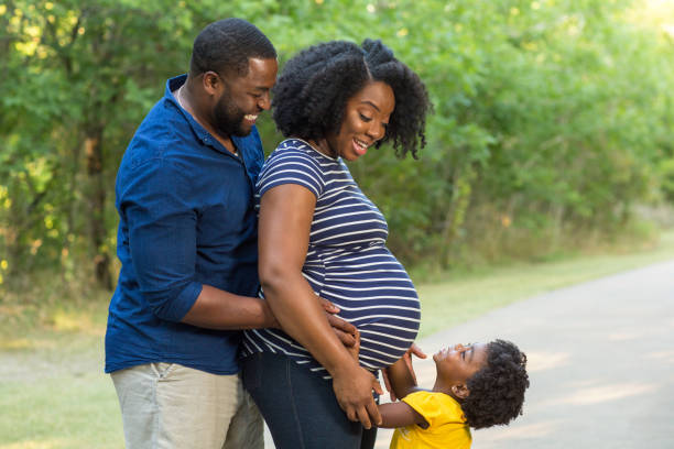 portret van een zwangere afrikaanse amerikaanse familie. - pregnant couple outside stockfoto's en -beelden