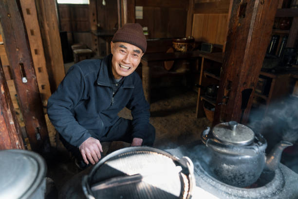 portrait of a senior japanese man in an old fashioned kitchen - idosos aquecedor imagens e fotografias de stock
