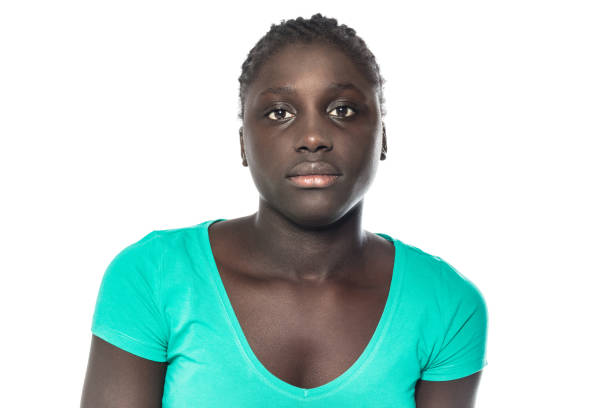 Portrait of a serious young woman Close up portrait of young african woman looking at camera. Serious young female wearing casuals against white background blank expression stock pictures, royalty-free photos & images