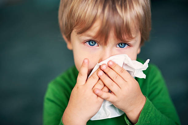 retrato de un niño enfermo limpiándose la nariz - afección médica fotografías e imágenes de stock