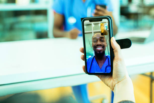 portret chorego pacjenta kaszel do tkanki jest wspomagany przez tele medycyny przez lekarza płci męskiej sobie niebieskie zarośla jednolite za pomocą telefonu komórkowego smartphone - video call zdjęcia i obrazy z banku zdjęć