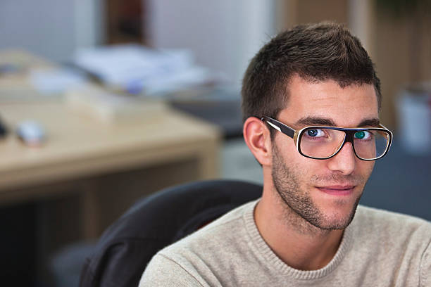 Portrait of a smart an handsome young man in office stock photo