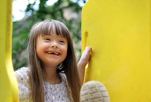 Portrait of a smiling girl playing Portrait of beautiful young girl on the playground. down syndrome stock pictures, royalty-free photos & images