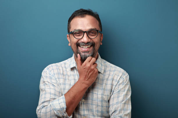 Portrait of a smiling middle aged man of Indian origin Portrait of a smiling middle aged man of Indian origin indian ethnicity stock pictures, royalty-free photos & images