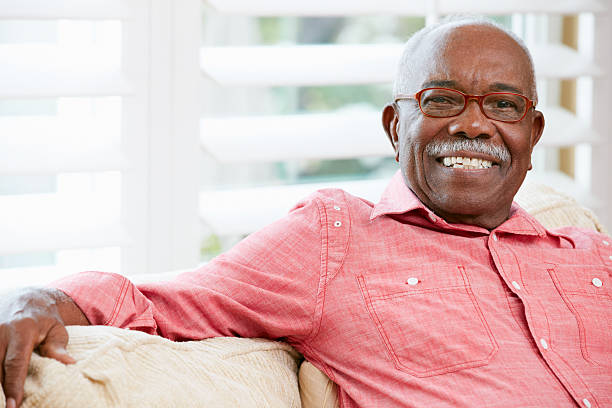 Portrait of a smiling senior man at home Portrait Of Happy Senior Man At Home Smiling To Camera senior men stock pictures, royalty-free photos & images
