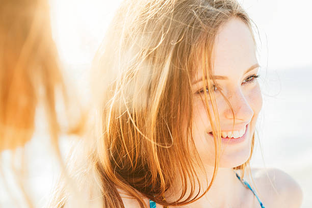 Portrait of a smiling woman on the beach at sunset stock photo