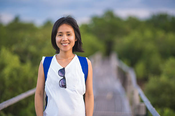 Portrait of a smiling woman Portrait of a smiling woman stood on a wooden bridge, looking towards the camera. Cebu, Philippines. December 2015 filipino woman stock pictures, royalty-free photos & images