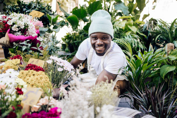 Portrait of a young African American florist working at his shop Portrait of a young African American florist working in his flower shop in Madrid. madridshop stock pictures, royalty-free photos & images
