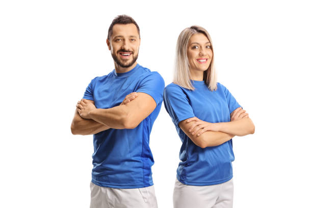 Portrait of a young male and female wearing blue sport jersey and posing with crossed hands stock photo