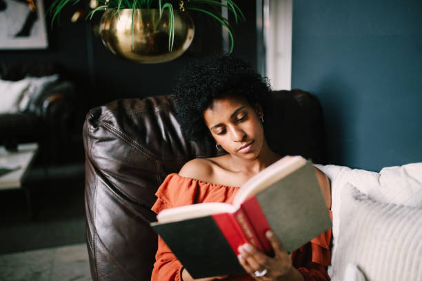 그녀의 다운 타운 로스 앤젤레스 아파트에서 휴식과 독서를 하는 젊은 여자의 초상화 - 읽기 뉴스 사진 이미지