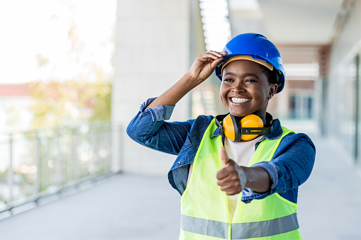 Portrait of a young woman working showing thumbs up at a construction site. Forget safety first, how about safety forever. Beautiful young female construction architect at a construction site. She showing thumbs up