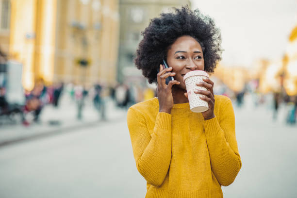 portret van afrikaanse amerikaanse vrouw in de stad - walking with coffee stockfoto's en -beelden
