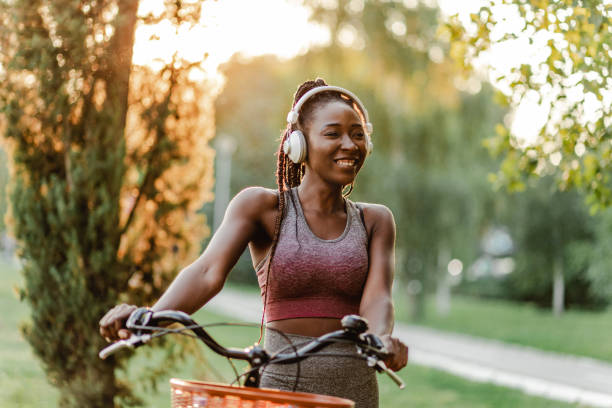 Portrait of African American woman riding bike in the park stock photo