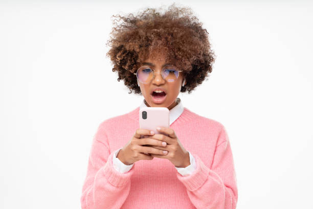 Portrait of african girl cringe and looking at phone screen with disgust, reading something disgusting, bad joke or inappropriate content Portrait of african girl cringe and looking at phone screen with disgust, reading something disgusting, bad joke or inappropriate content disgust photos stock pictures, royalty-free photos & images