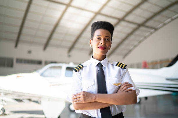 Portrait of airplane pilot in a hangar and looking at camera Portrait of airplane pilot in a hangar and looking at camera pilot stock pictures, royalty-free photos & images