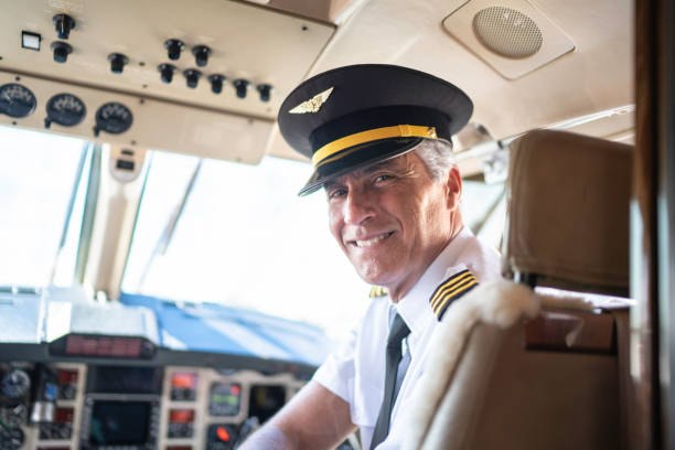 Portrait of airplane pilot looking over shoulder in a private jet Portrait of airplane pilot looking over shoulder in a private jet pilot stock pictures, royalty-free photos & images