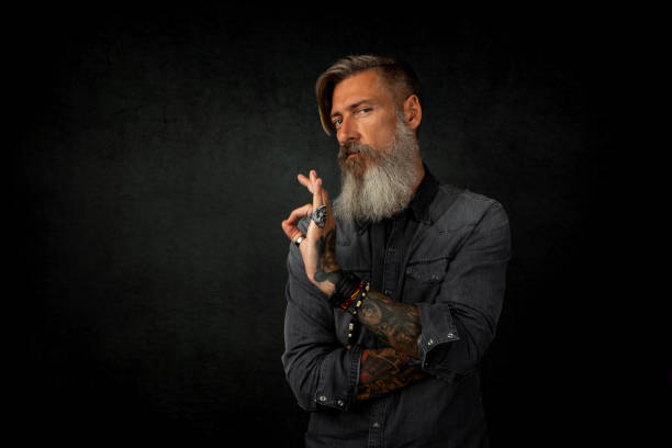 Portrait of an attractive bearded hipster showing with his Finger that he is satisfied stock photo