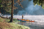 istock Portrait of an young woman fishing while camping next to beautiful lake. 1306308972