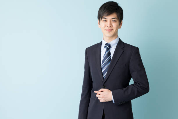 青の背景に分離したアジア系のビジネスマンの肖像画 - スーツ　男性 ストックフォトと画像