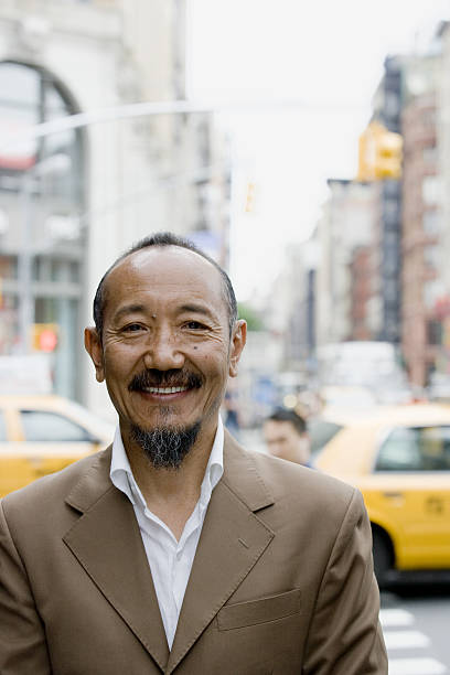 Portrait of asian mature man in downtown city Portrait of asian mature man in downtown city, New York City tibetan ethnicity stock pictures, royalty-free photos & images