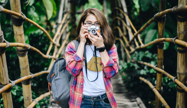 Portrait of Asian woman using mirrorless camera while traveling. stock photo