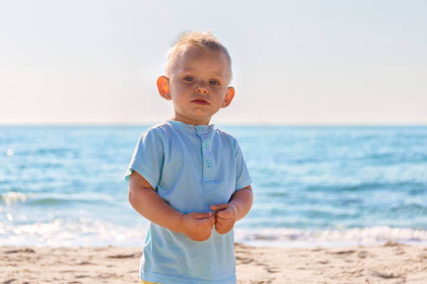 porträtt av förvånad liten blond pojke på stranden - dwarf rabbit bildbanksfoton och bilder