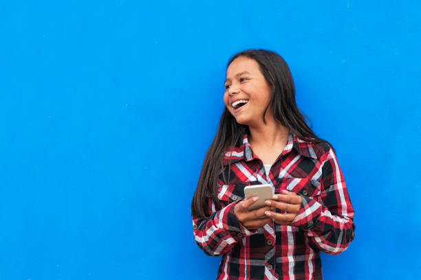 Portrait of beautiful latino girl using the mobile in the street. Portrait of beautiful latino girl using the mobile in the street. Childhood Concept. latina girl stock pictures, royalty-free photos & images