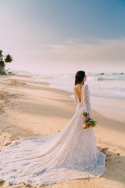 portrait of bride in full growth on tropical beach stock photo