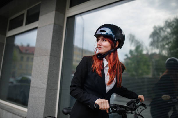 Portrait of businesswoman commuter on the way to work with bike, sustainable lifestyle concept. stock photo