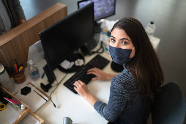 Portrait of businesswoman / receptionist working wearing face mask Portrait of businesswoman / receptionist working wearing face mask secretary stock pictures, royalty-free photos & images